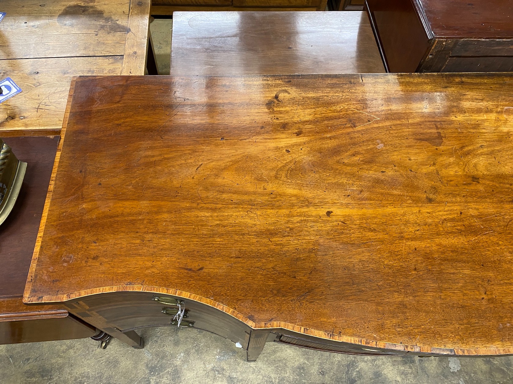 A George III satinwood banded mahogany serpentine sideboard with central tambour compartment, width 199cm, depth 80cm height 95cm